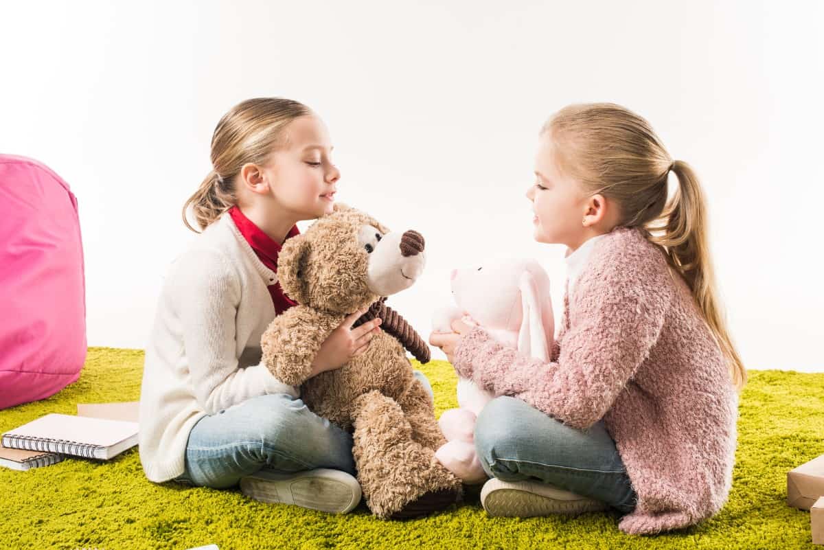 Two girls playing with stuffed toys.