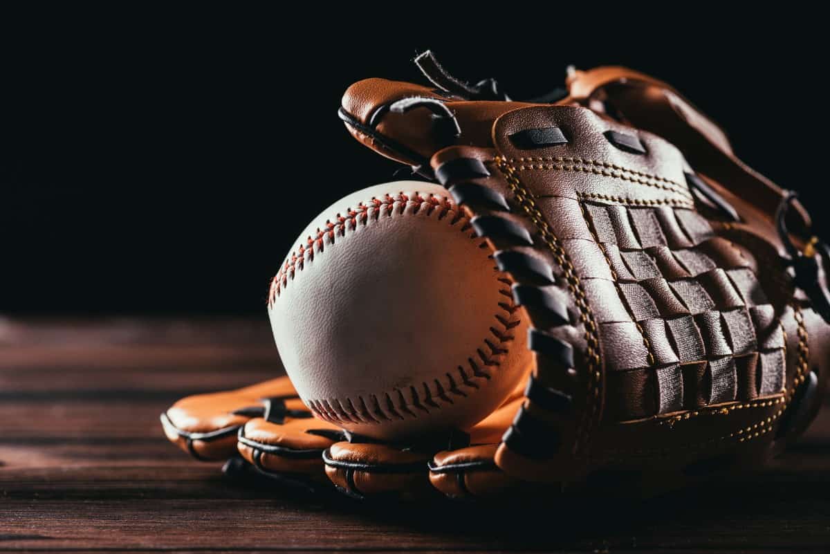 Leather baseball glove holding a baseball ball.