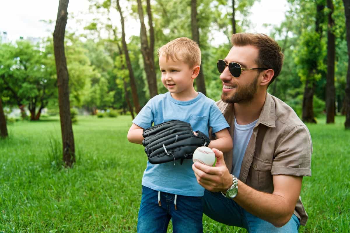 Dad teaching son to play baseball.