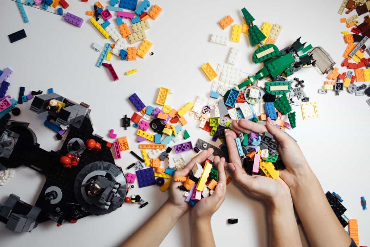 Hands playing with Legos.