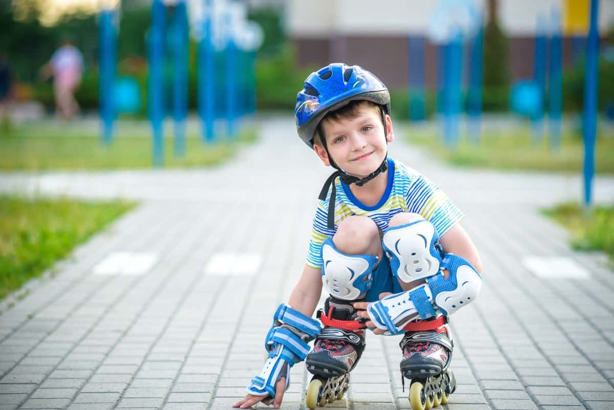 Little boy rollerblading in the park.