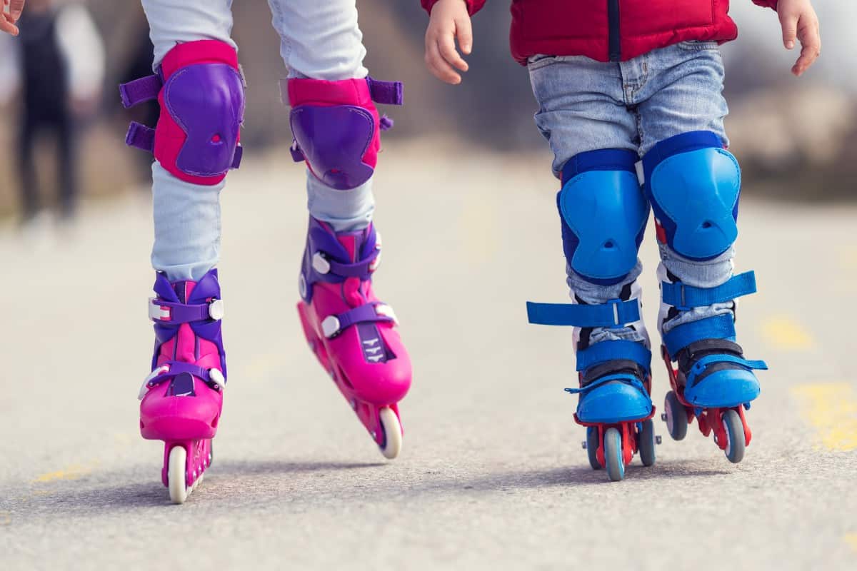 Little boy and girl wearing rollerblades.