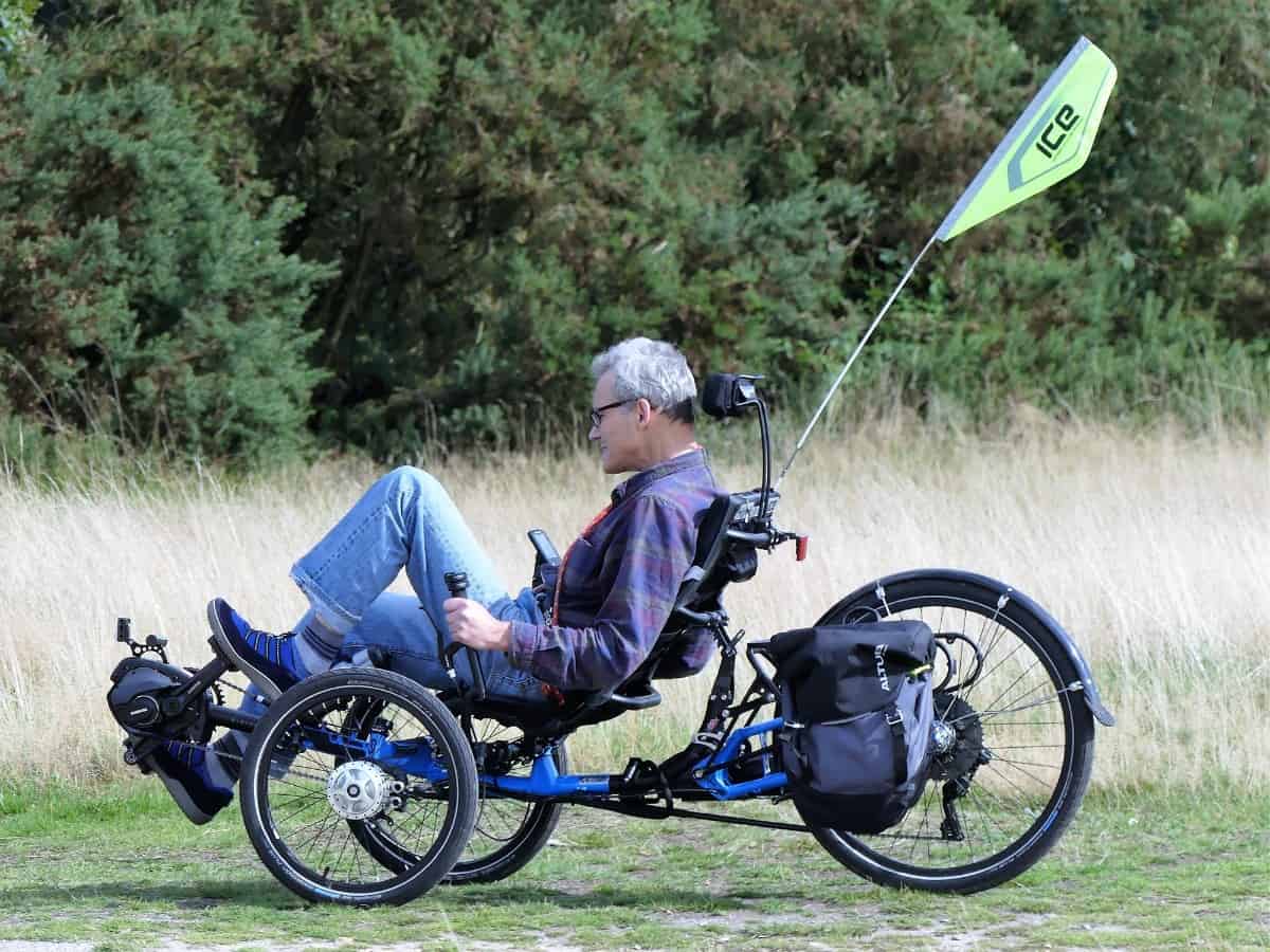 Senior man riding a trike in the field.