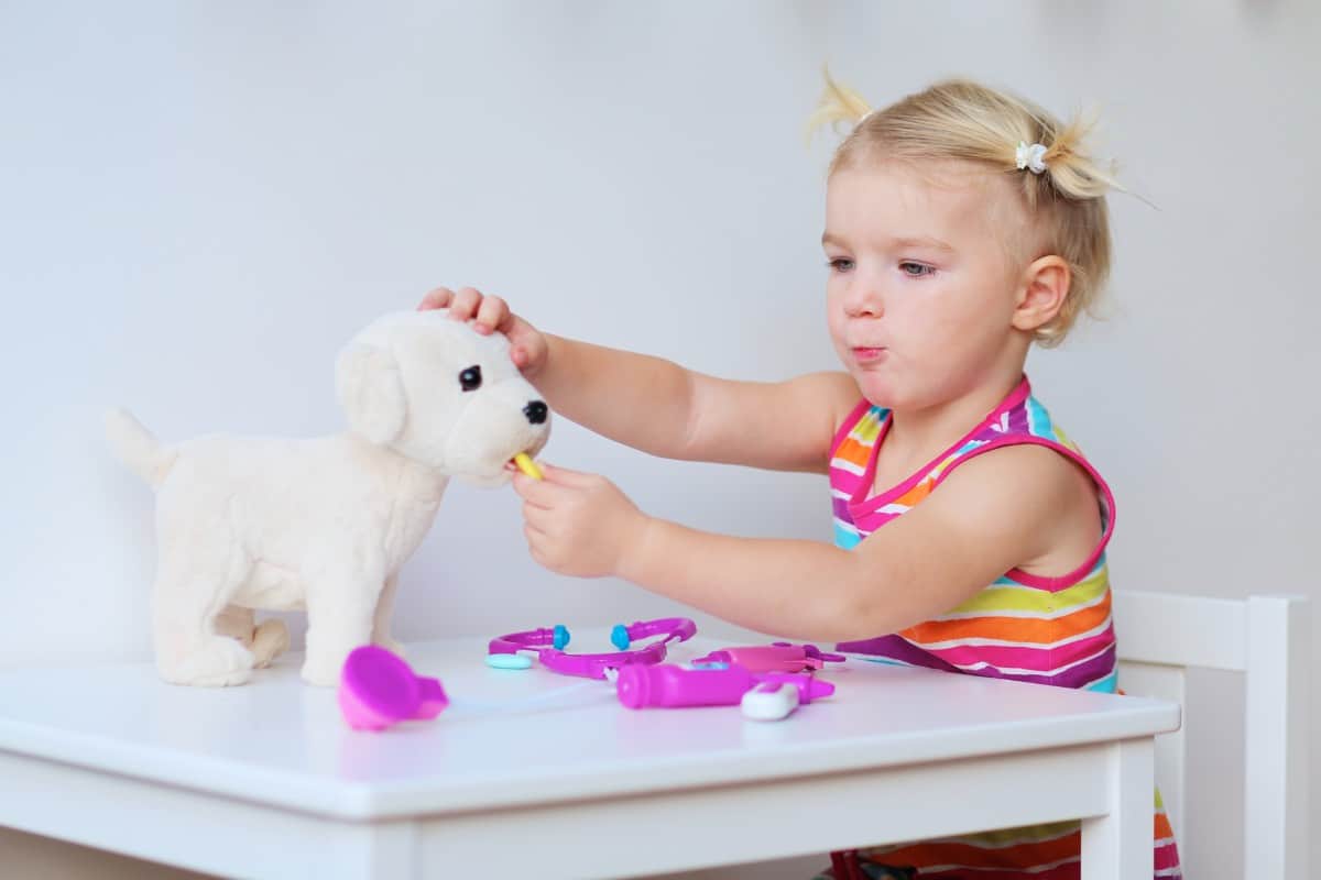 Little girl playing with toy dog.
