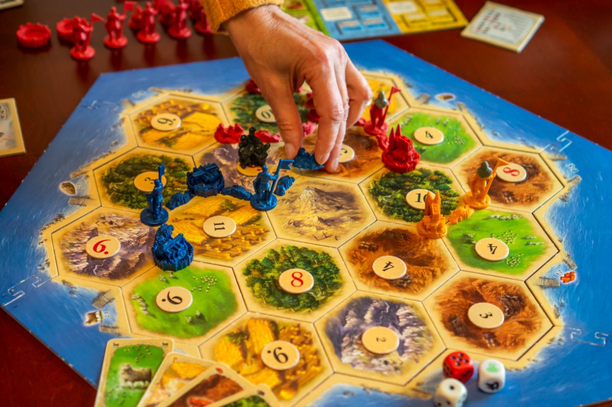 Board game catan and three pieces of dice.