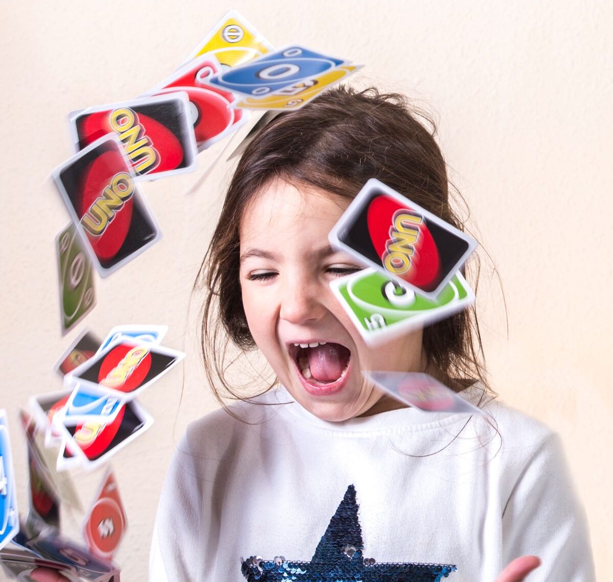 A little girl playing UNO cards.