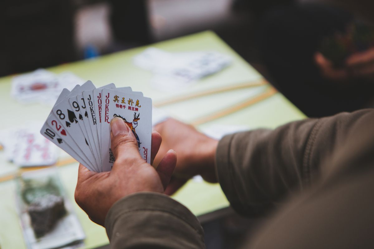 A man playing cards holding 3 jokers.