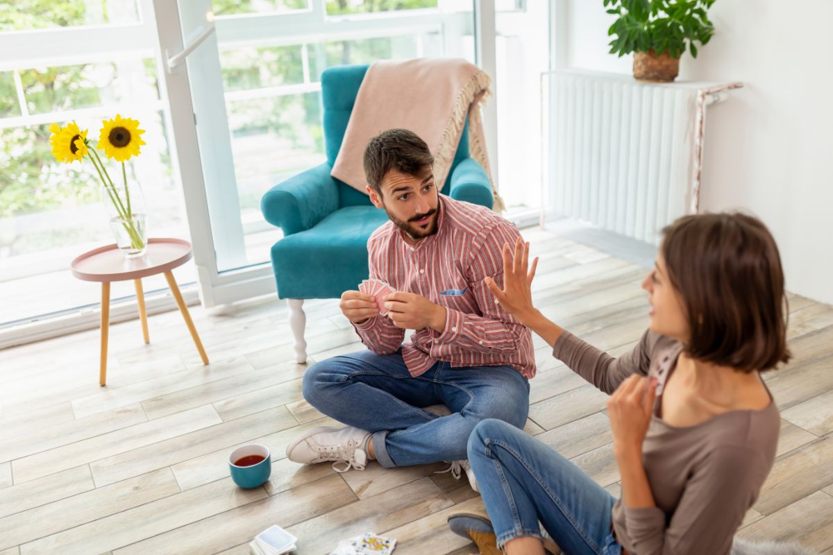 2 Player Card Games: What Card Games Can You Play With 2 People? 5 Couple playing cards on the floor.