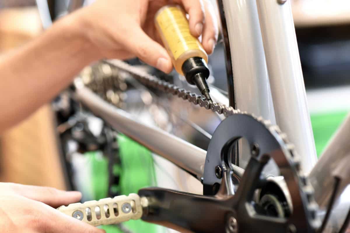 Mountain Bike Chain: How Often Should You Oil? 3 Oil being applied on a mountain bike chain.