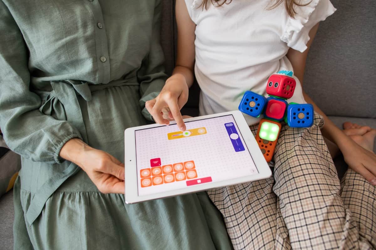 Mother teaching daughter simple programming.