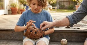 child trying on baseball glove for size fit